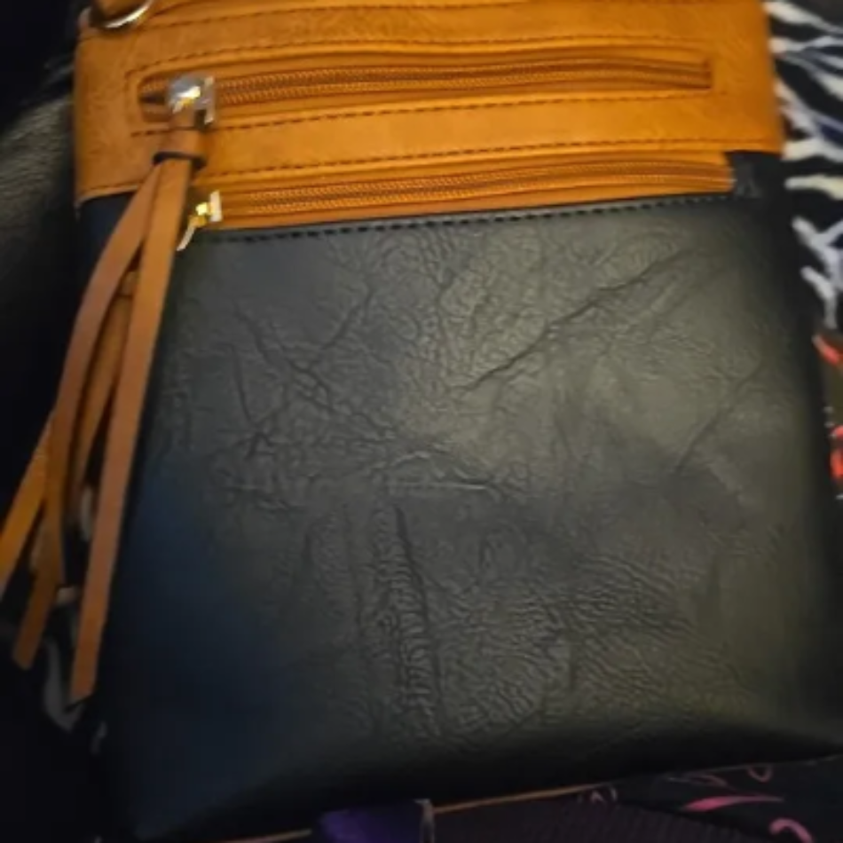 Sac bandoulière vertical pour femme avec plusieurs poches zippées.